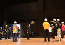 23日（木）朝、舞台設営を開始する前にカンパニーの技術スタッフと利尻町役場の皆さんでミーティング。舞台監督・宮澤勝大（中央）より、安全に気を付けるよう挨拶がありました