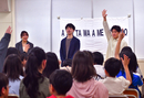 あざみ野第二小学校での授業の様子（右より、劇団四季俳優・島村幸大さん、勝原亮太さん、熊谷春花さん）。俳優からの問いかけに、元気よく手を挙げる子どもたち